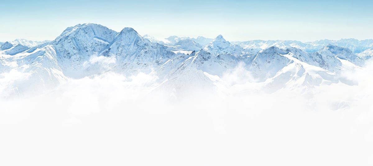 Schneebedeckte Berggipfel ragen über einer Wolkendecke unter klarem blauem Himmel empor